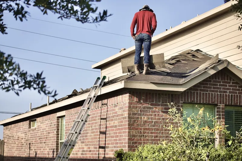 Professional roofer working on a residential roof in Hamptons at Boca Raton